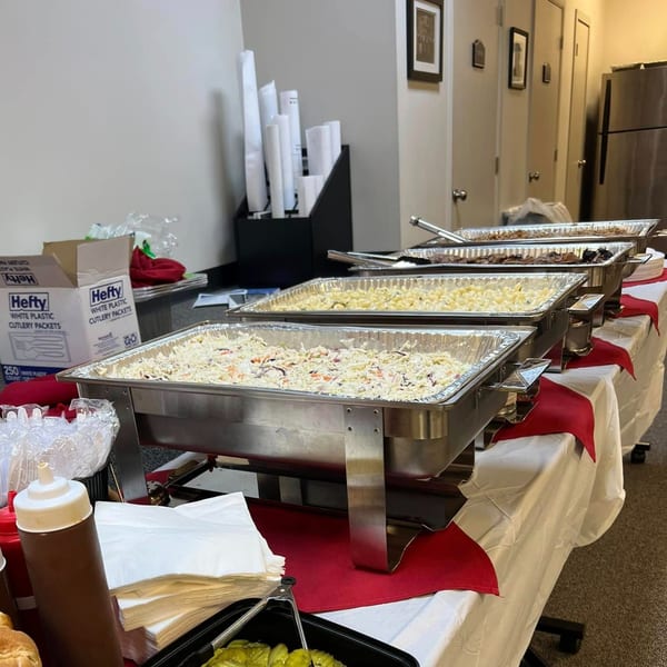 A buffet table with F325 BBQ catering dishes, including macaroni and cheese, and other sides.