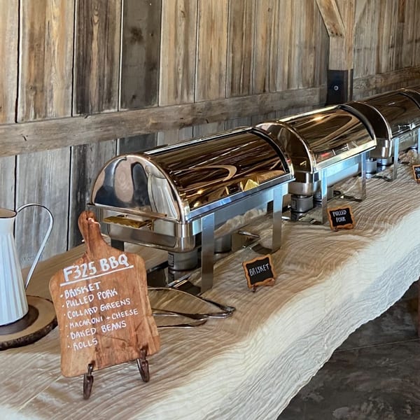 F325 BBQ buffet line with chafing dishes, a menu board, and small food labels.